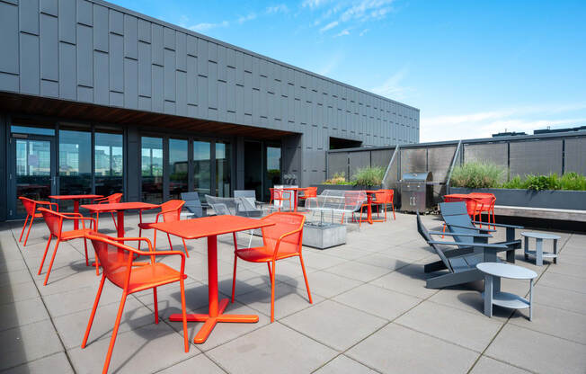 an outdoor patio with orange tables and chairs