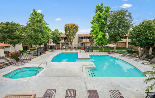 our apartments have a swimming pool with chairs and trees