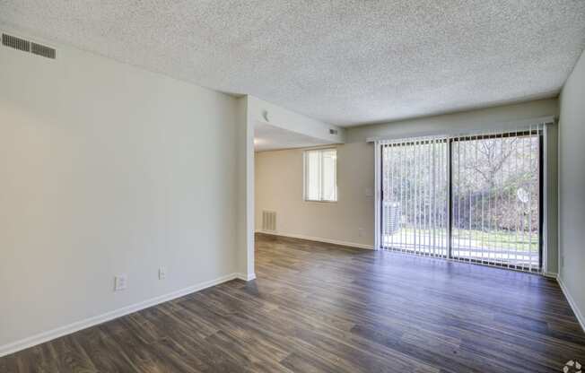 the spacious living room and dining room of an apartment