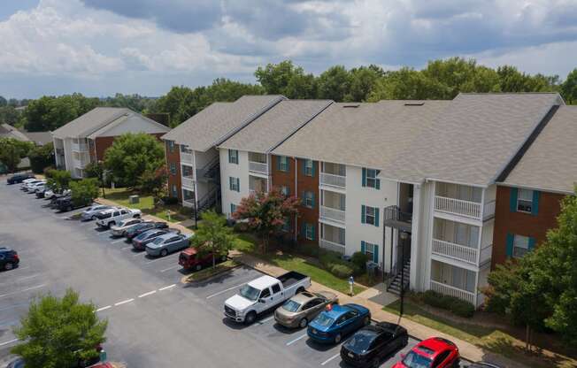 an aerial view of an apartment complex with a parking lot