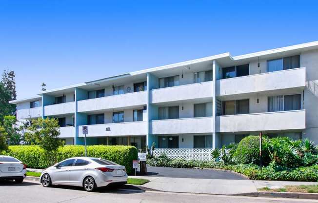 a white car parked in front of an apartment building