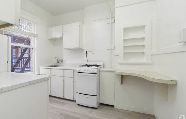 a white kitchen with a stove and a window at Clay & Tiffany, Portland, OR