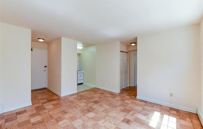 vacant living area with hardwood floors and view of entrance at alpha house apartments in washington dc