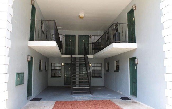 the inside of a building with stairs and a balcony