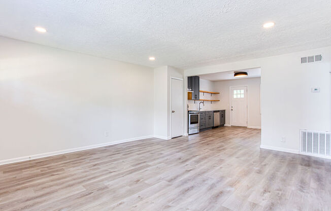 a spacious living room with a kitchen in the background  at The Oasis on Cascade, Atlanta, GA, 30310