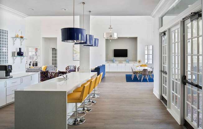 a kitchen with a long white counter and yellow chairs