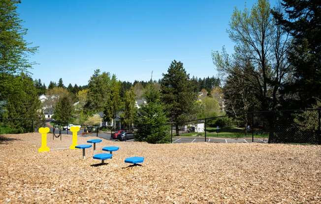 a park with a playground and blue benches