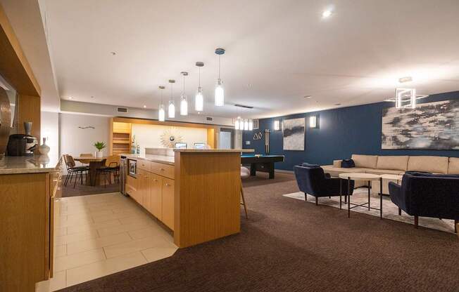 A modern kitchen and living room area with a wooden counter and blue couch.