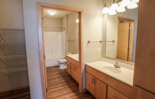 A bathroom with a toilet, sink, and mirror.