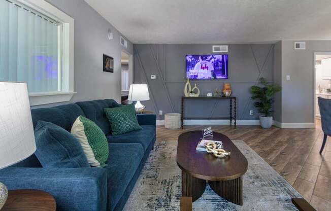 The leasing office with a blue couch and a television on the wall at The Summit at Midtown Apartments in Midtown, Dallas, TX.