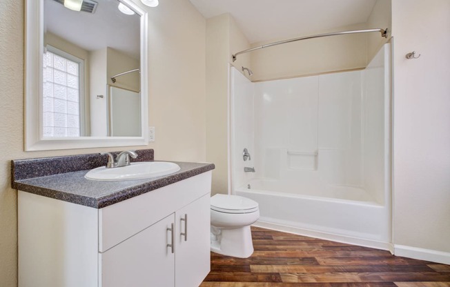 bathroom with wood floors, and shower/tub combo