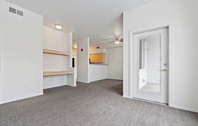 A room with a white door, a window, and a ceiling fan.