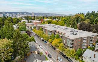 A view of a city from a high vantage point with apartment buildings and cars.