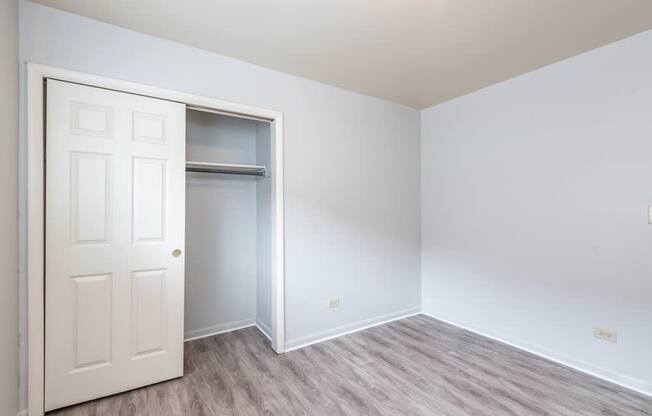 A white door is open to a room with a grey floor.