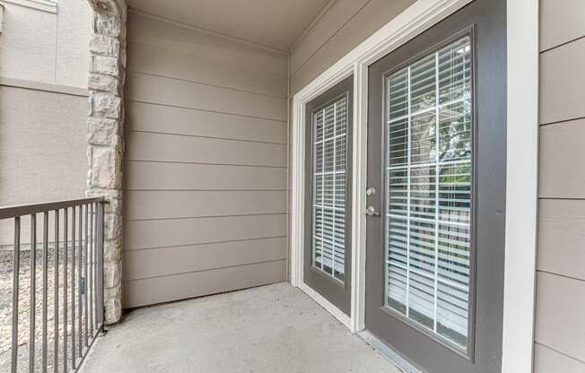 A balcony with a sliding glass door and a metal railing.