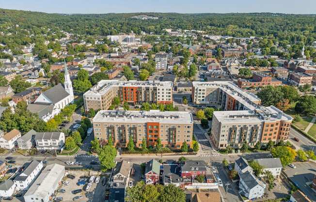 an aerial view of a city with buildings and trees at The Merc, Massachusetts, 02453