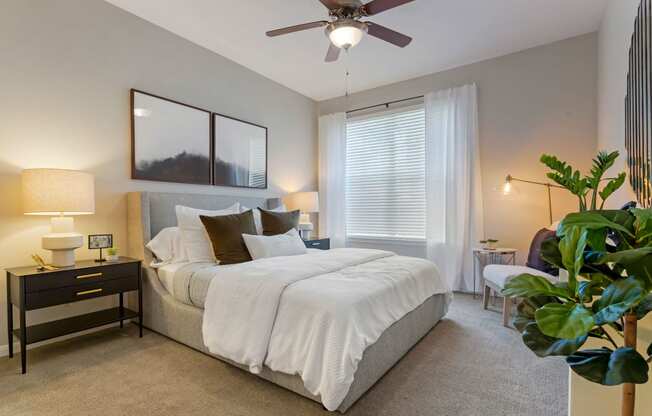 a bedroom with a large bed and a ceiling fan at Madison on the Meadow, Stafford, TX