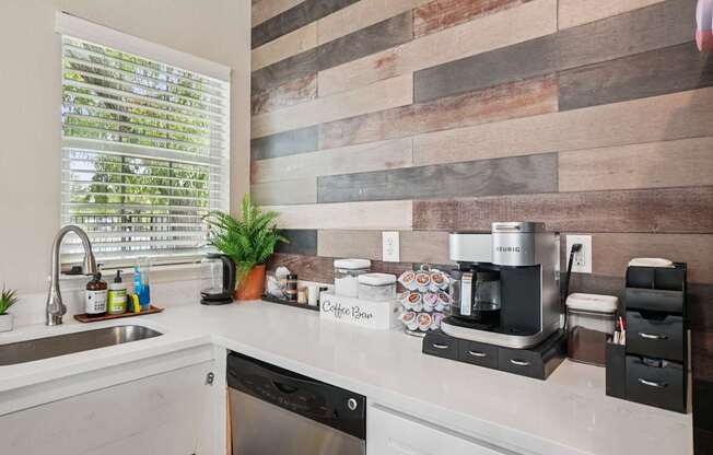 A kitchen with a wooden backsplash and a coffee maker on the counter.