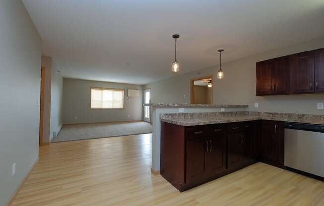 an empty kitchen and living room with wood flooring. Fargo, ND Urban Plains Apartments