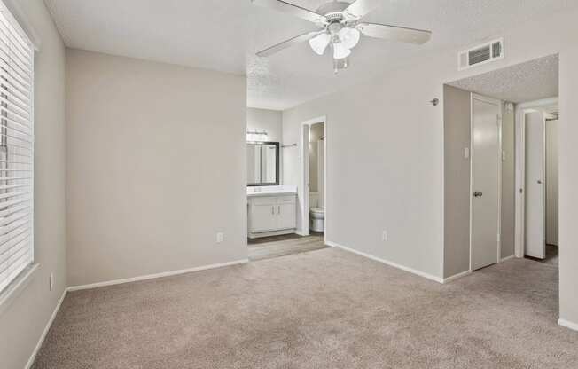 an empty bedroom with a ceiling fan