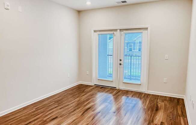 A room with a wooden floor and a sliding glass door.