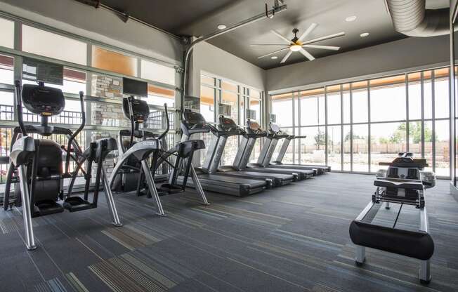 Fitness Center with four treadmills, three ellipticals and row machine on tactical carpeted floor