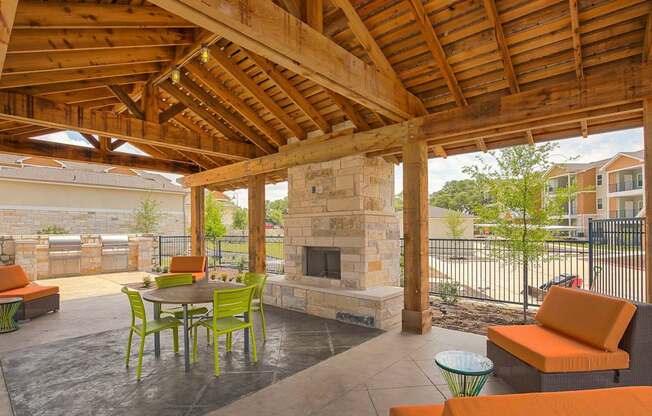 A patio with a fireplace and chairs.
