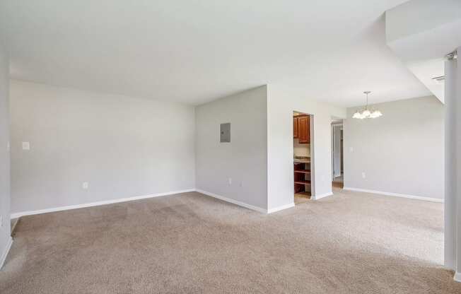 an empty living room with white walls and carpet