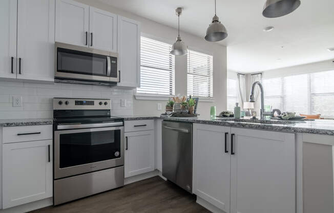 a kitchen with white cabinets and stainless steel appliances
