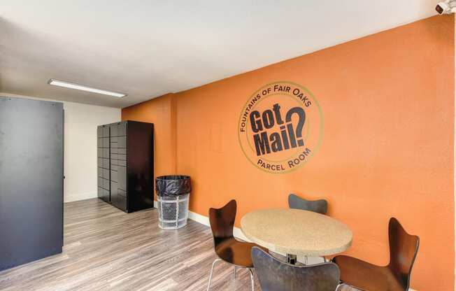 Parcel Room with Hardwood Inspired Floor, Short Round Tables, Chairs, Orange Wall with 