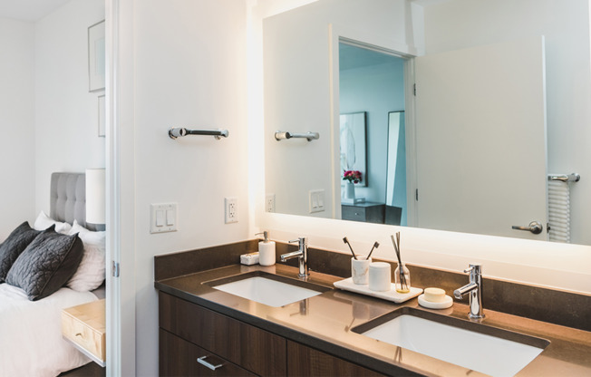Dual vanities with quartz countertops and LED backlit mirror