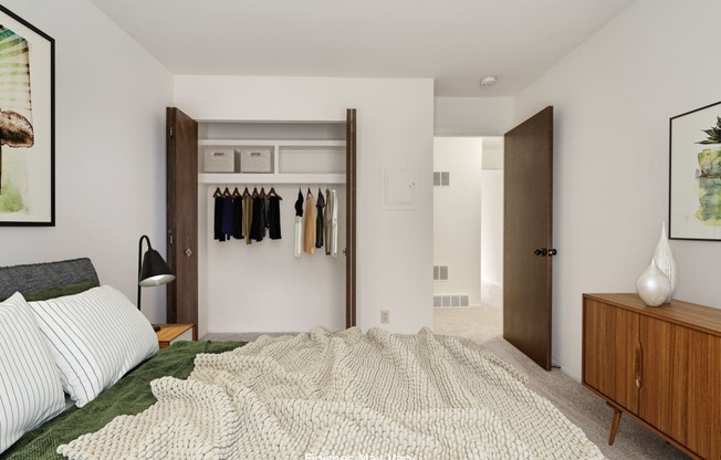 a bedroom with white walls and a large bed with a white blanket