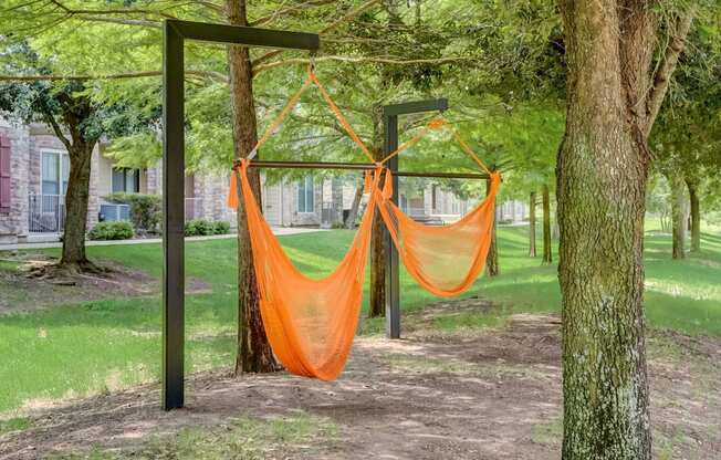 a hammock in the shade of trees in a park