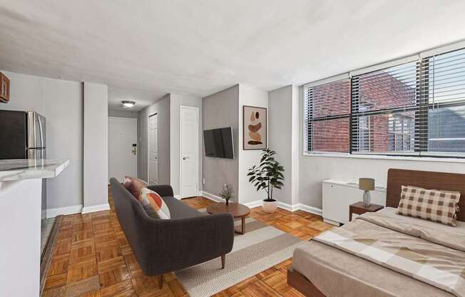 A living room with a brown couch and a bed.