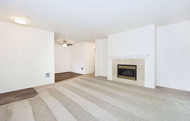 an empty living room with a fireplace and white walls