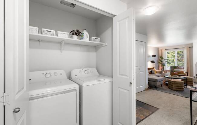 a white laundry room with two washes and a dryer