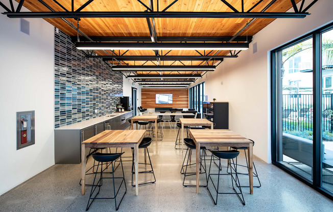 A modern kitchen with a long table and chairs.
