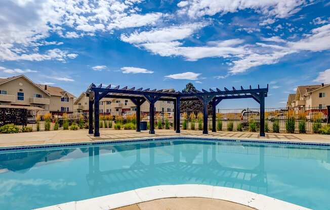Sparkling swimming pool with pergola lounge area at Aurora Meadows in Colorado.