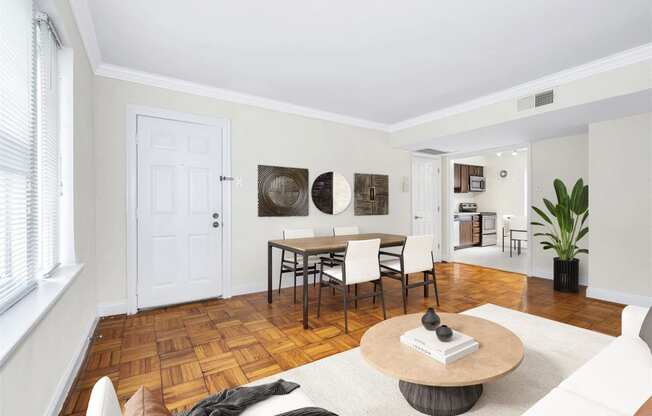 the living room and dining room of a house with a table and chairs