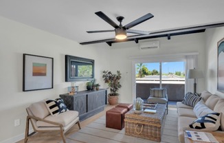 a living room with a couch and a ceiling fan