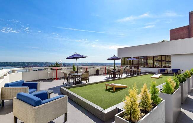 A rooftop patio with a table and chairs overlooking the water.
