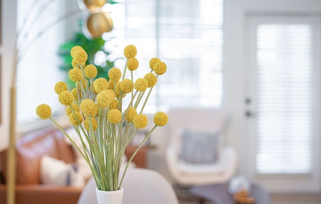 a vase of yellow flowers in a living room