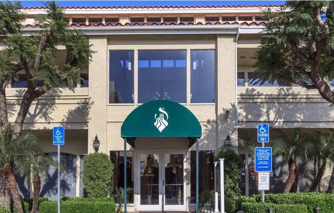 a building with a green awning and palm trees