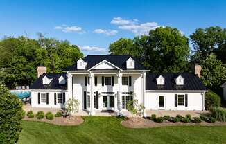 an aerial view of a white house with a black roof