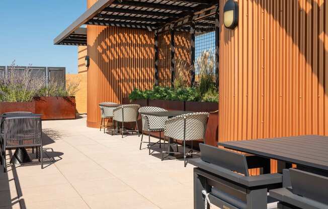 a patio with tables and chairs and a wood fence