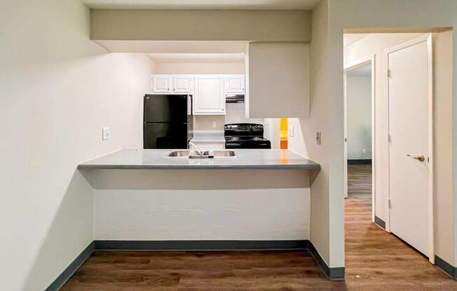 A kitchen with a black fridge and a black microwave at The Hampton Meadows Apartments, Des Moines, IA, 50315