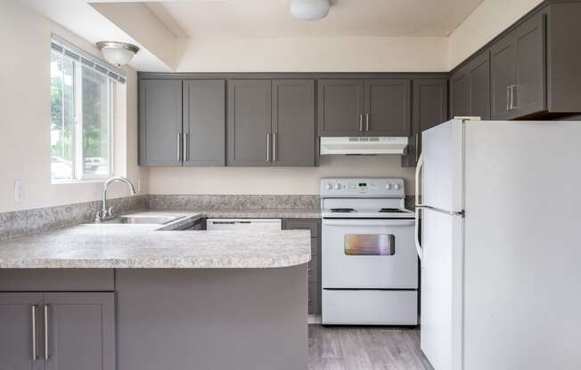 a kitchen with gray cabinets and white appliances