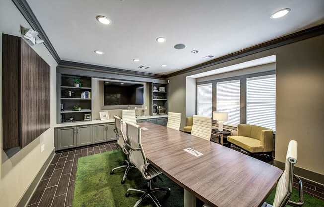 a conference room with a table and chairs and a television