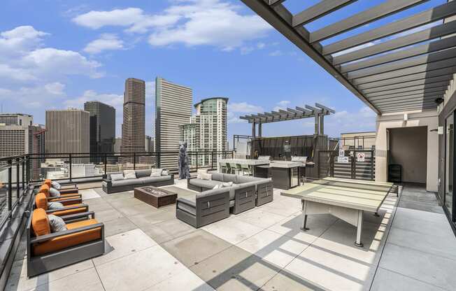 a rooftop patio with furniture and a view of the city