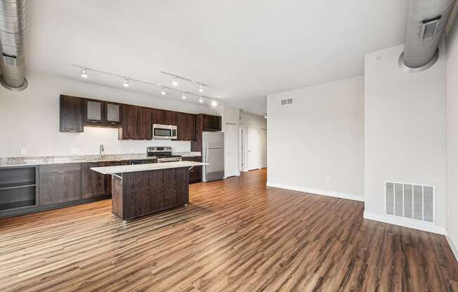A kitchen with wooden floors and a white wall.